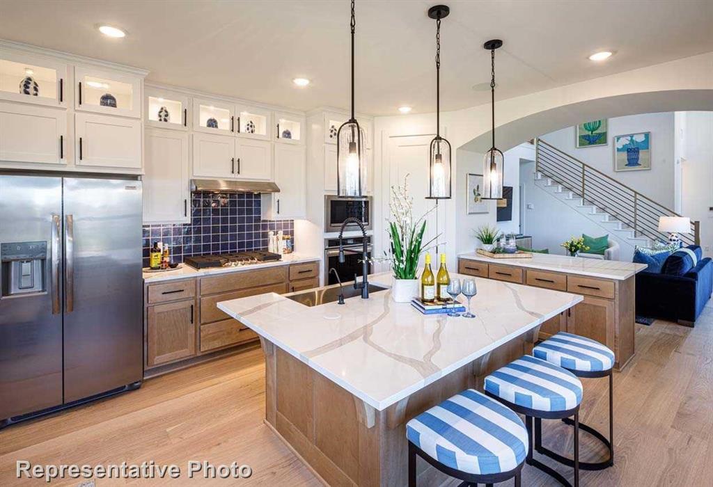 a kitchen with stainless steel appliances kitchen island granite countertop a table chairs and a refrigerator