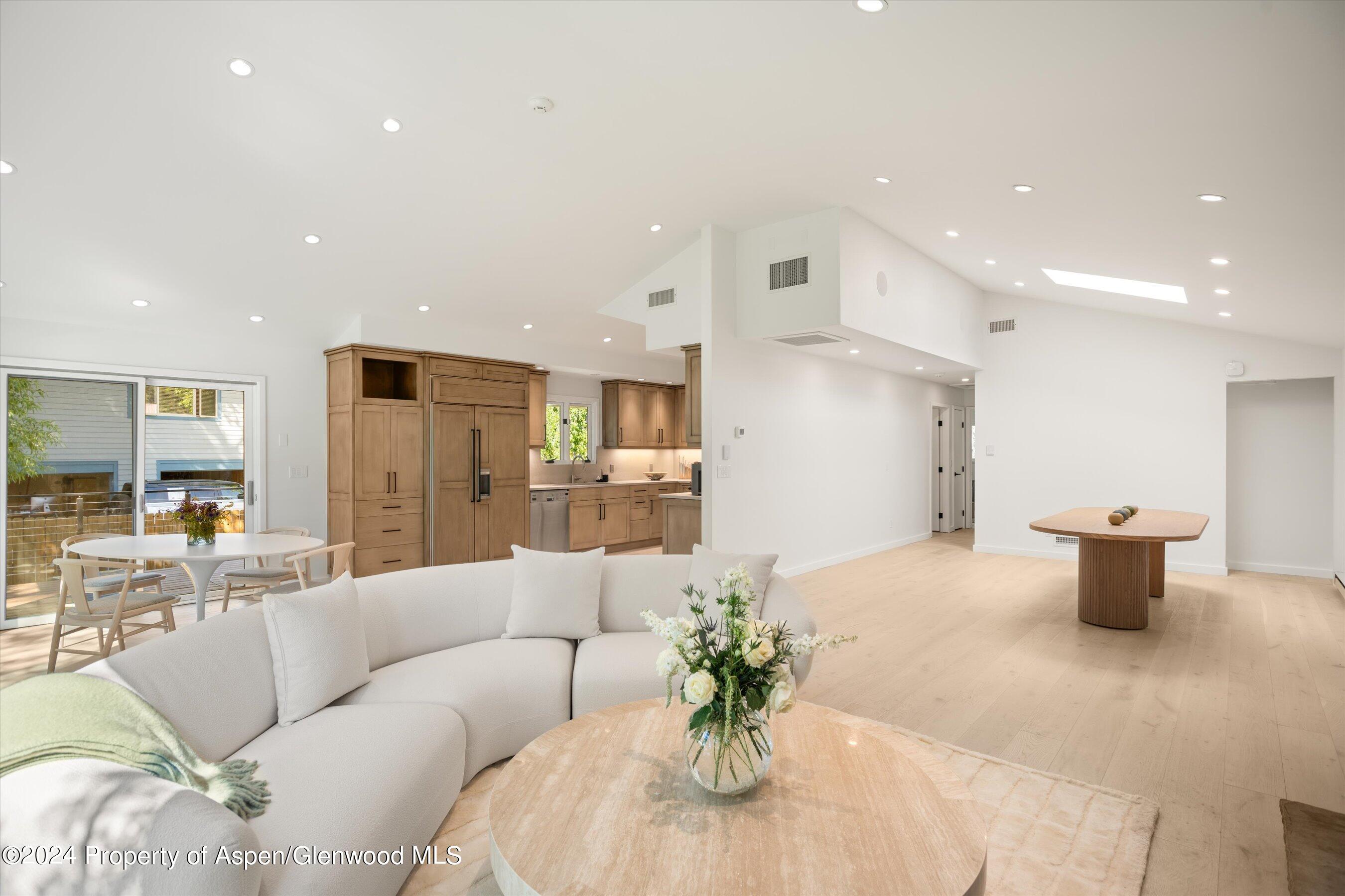 a living room with furniture kitchen view and a potted plant