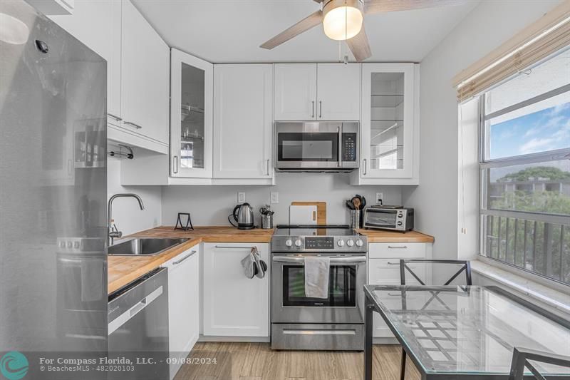 a kitchen with stainless steel appliances a stove a sink cabinets and a refrigerator