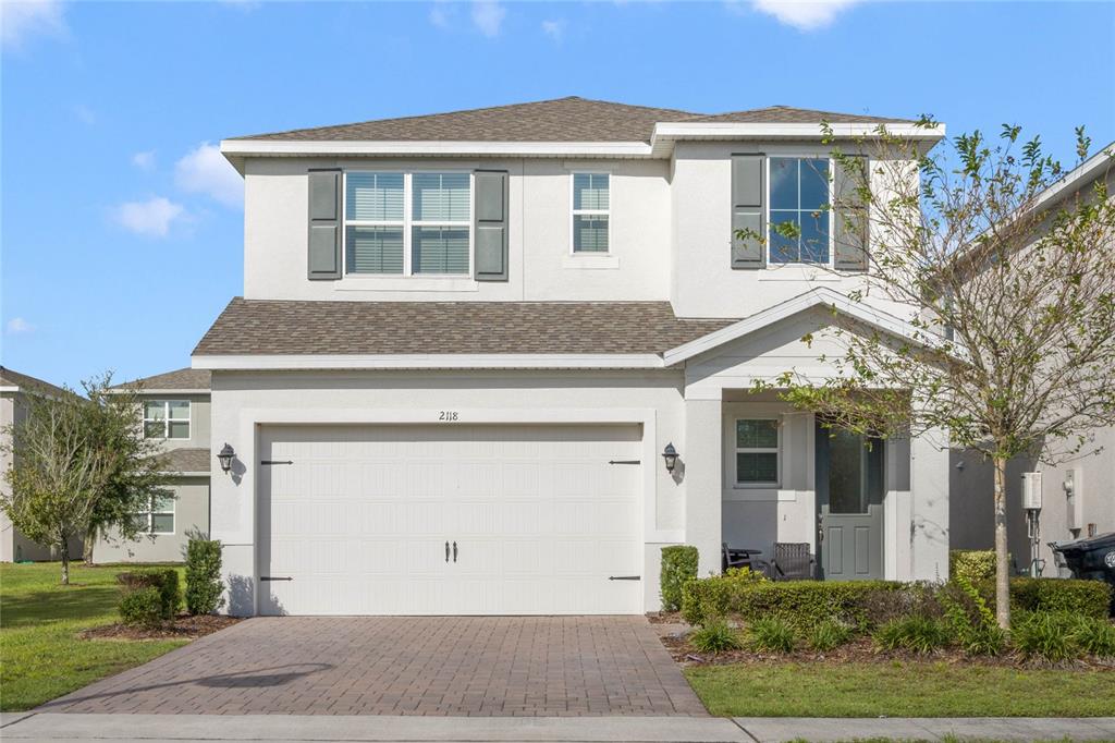 a front view of a house with a yard and garage