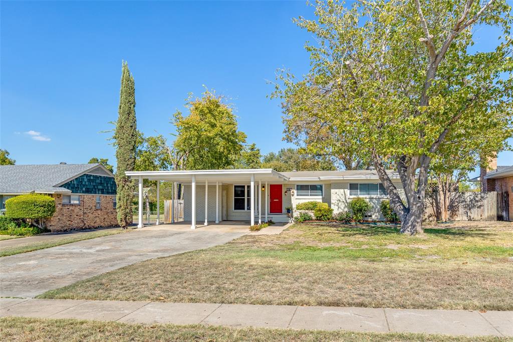 a front view of a house with a yard and trees