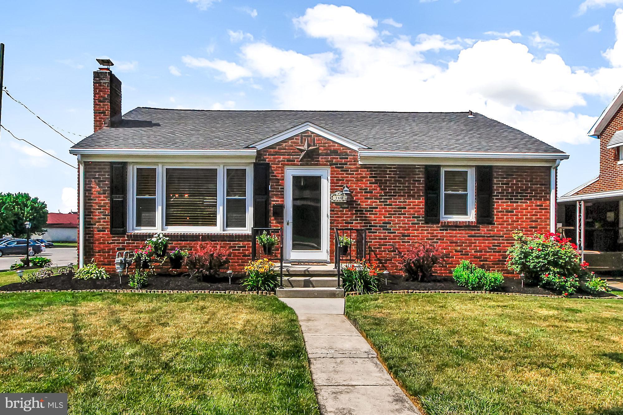 a front view of a house with a garden and plants