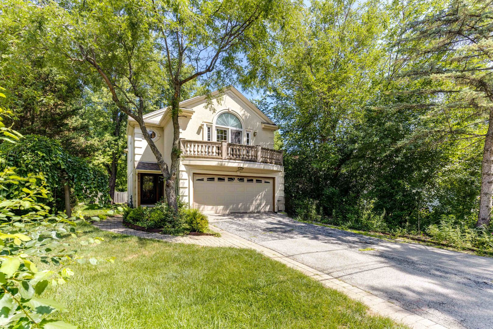 a front view of a house with a yard and trees