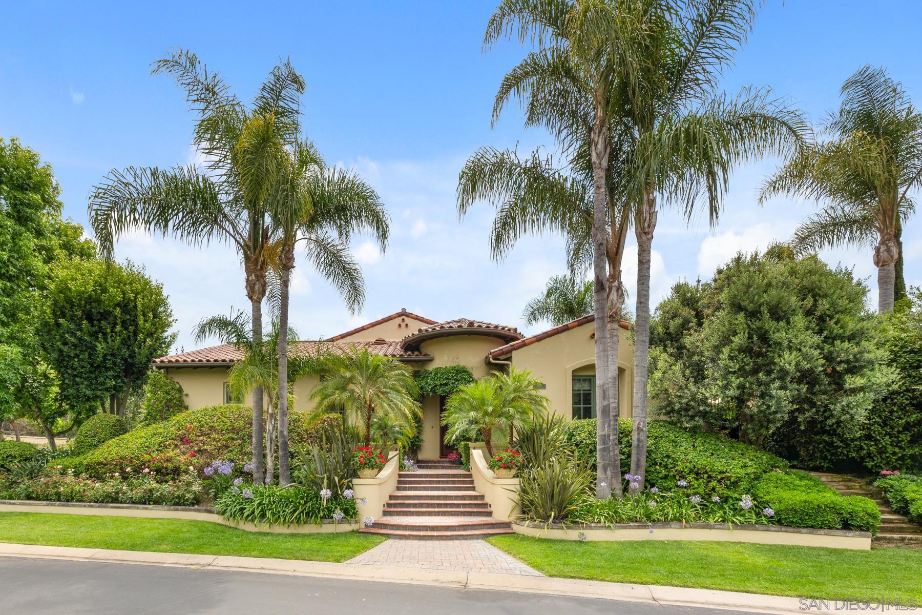 a front view of a house with a garden and swimming pool