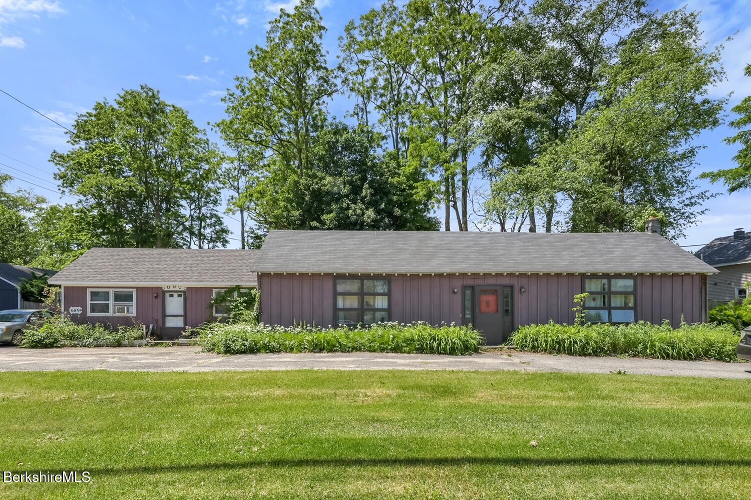 a front view of a house with a garden