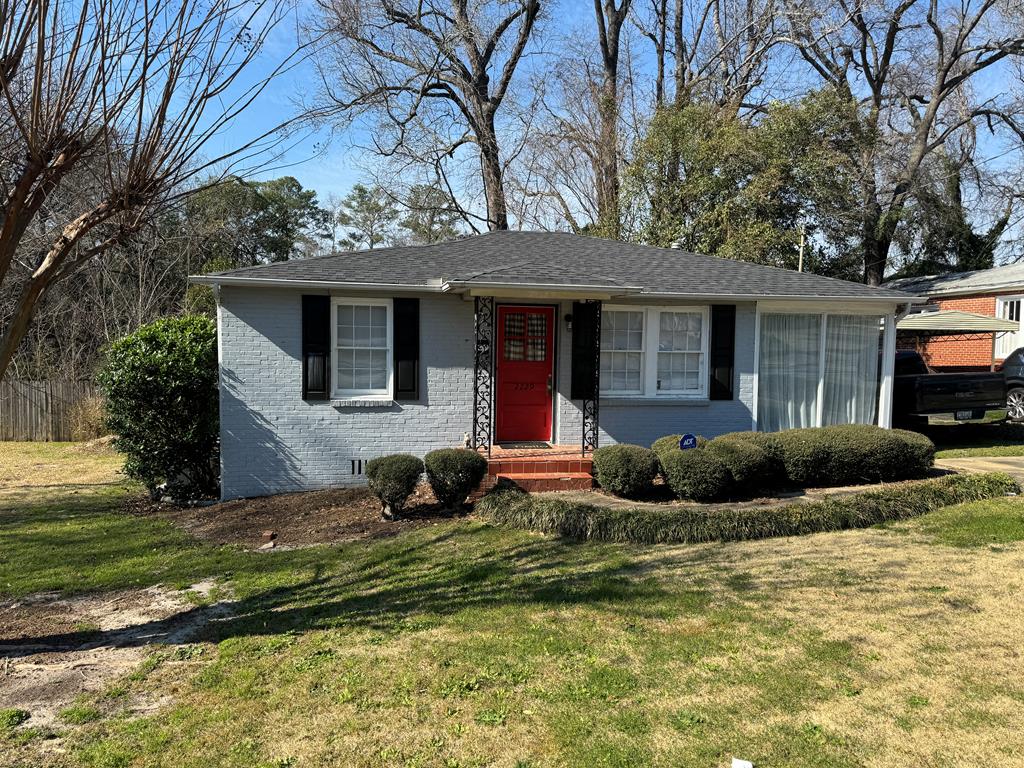 a view of a house with a backyard and tree