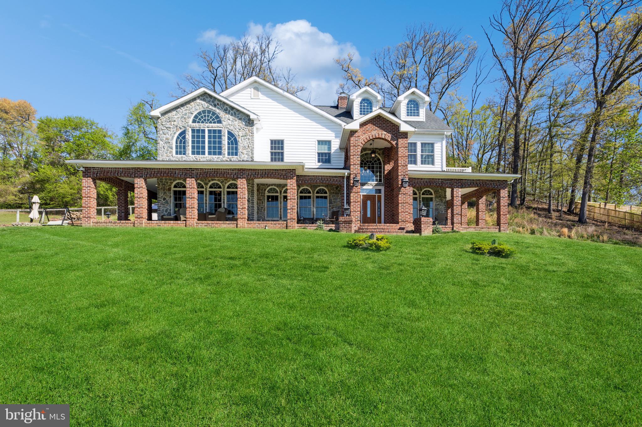 a front view of a house with a garden and trees