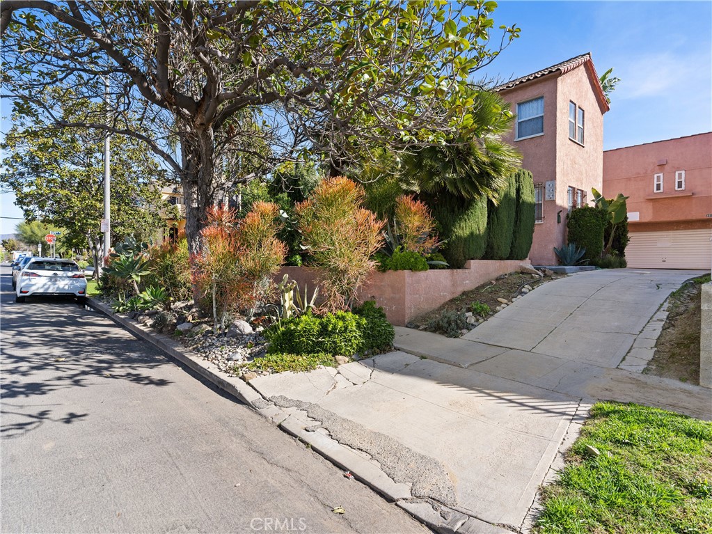 a pathway of a house with a yard and sitting area