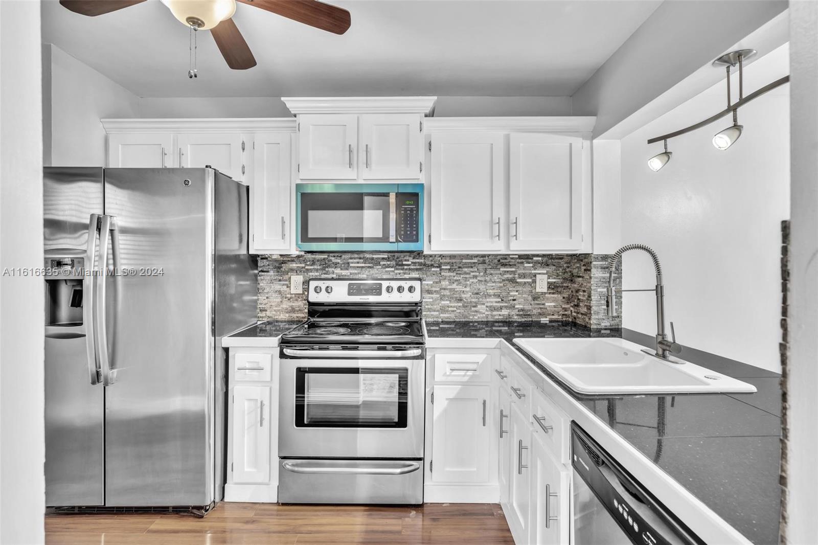 a kitchen with a sink appliances and cabinets