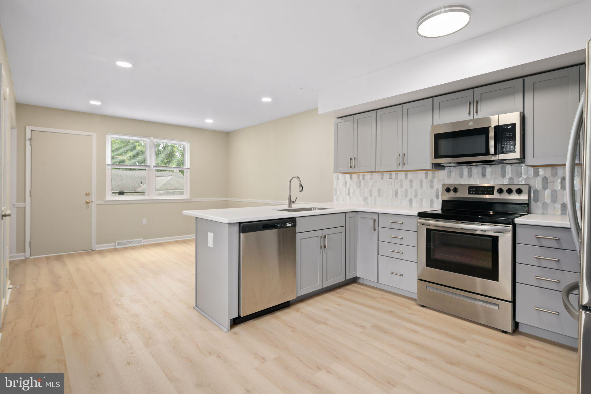 a kitchen with stainless steel appliances granite countertop a stove a sink and a microwave