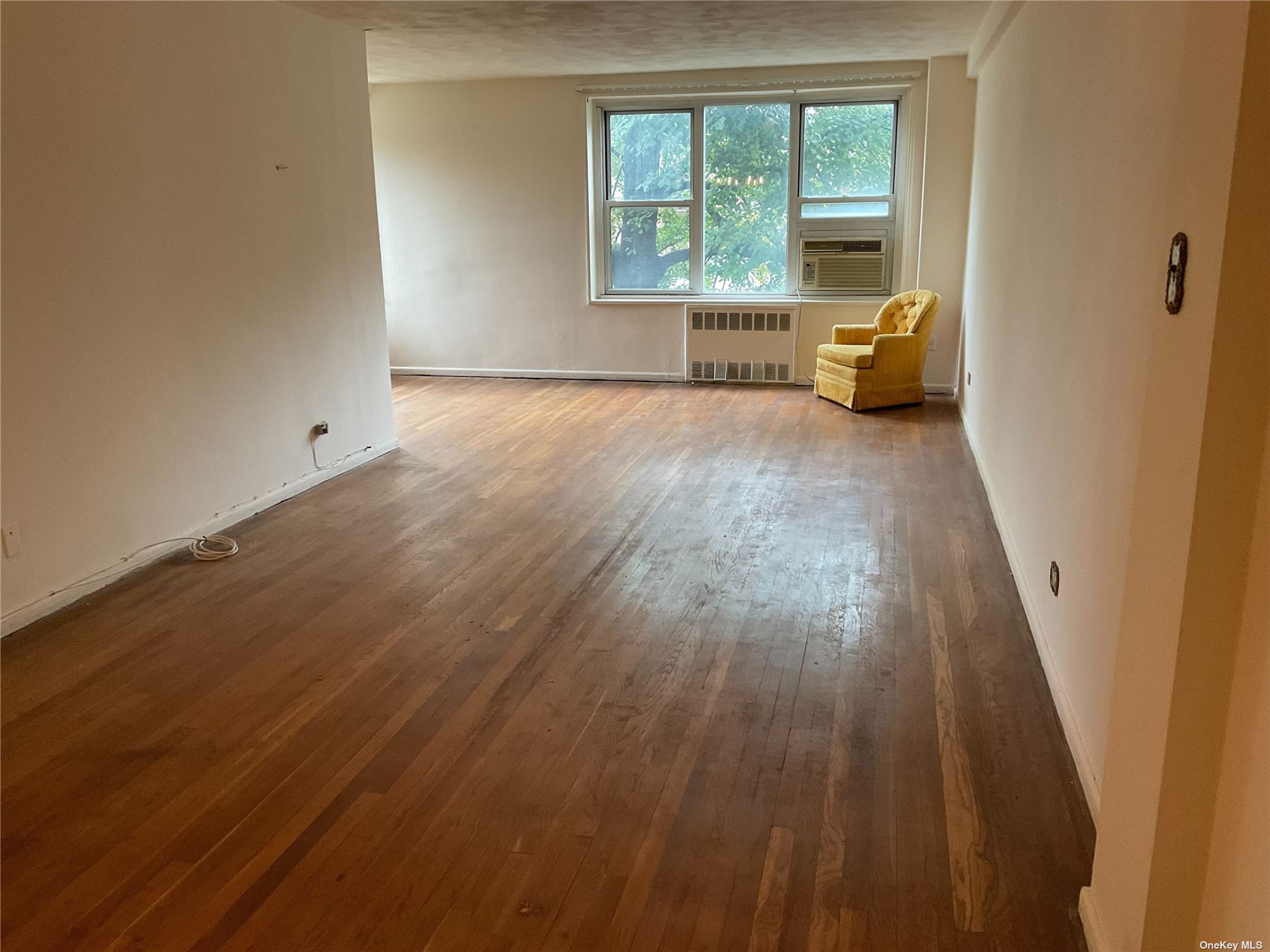 an empty room with wooden floor and a window