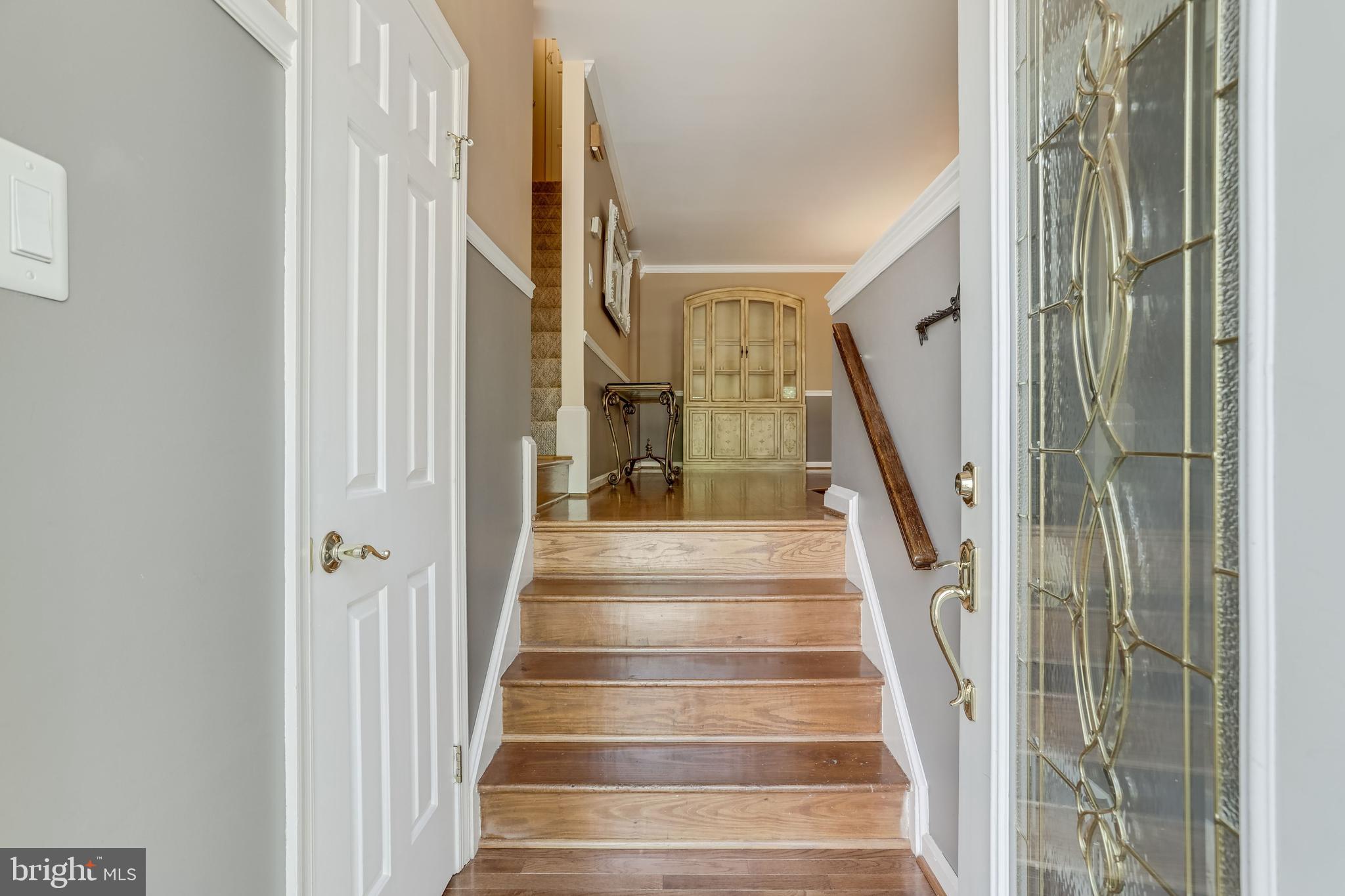 a view of staircase with lots of frames on wall and wooden floor