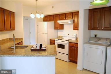 a kitchen that has a microwave a stove and white cabinets