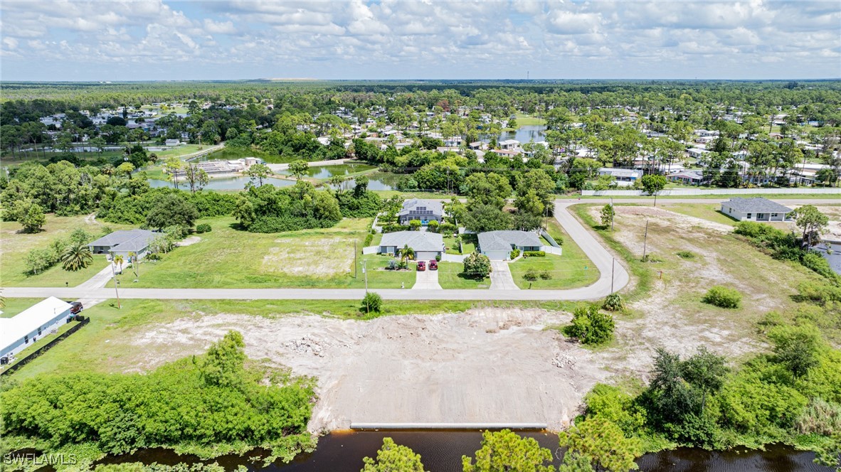 an aerial view of residential houses with outdoor space and trees