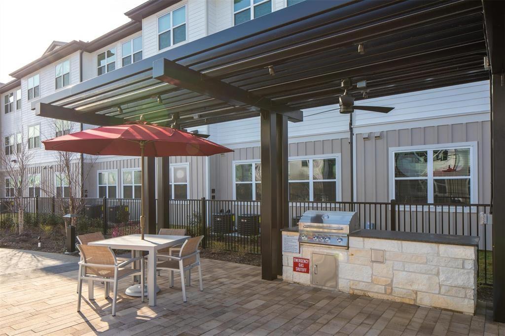 a patio with a table and chairs and potted plants