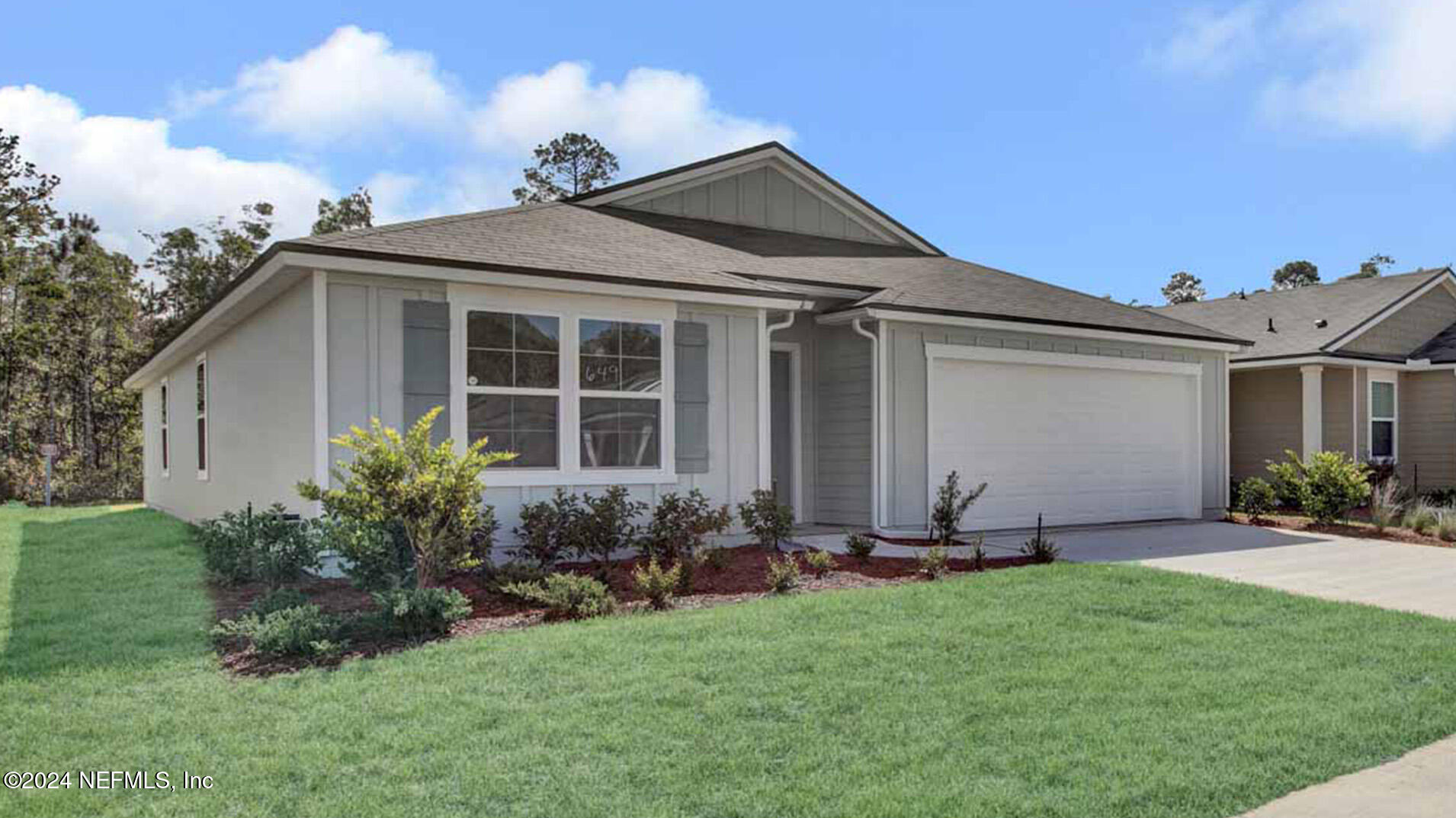 a front view of a house with a garden and plants