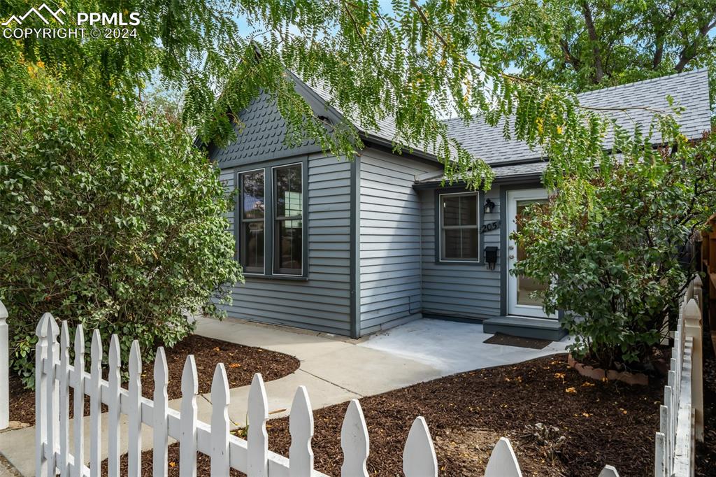 a view of a house with a yard and wooden fence