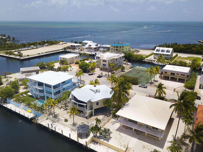 an aerial view of a house with a garden and lake view