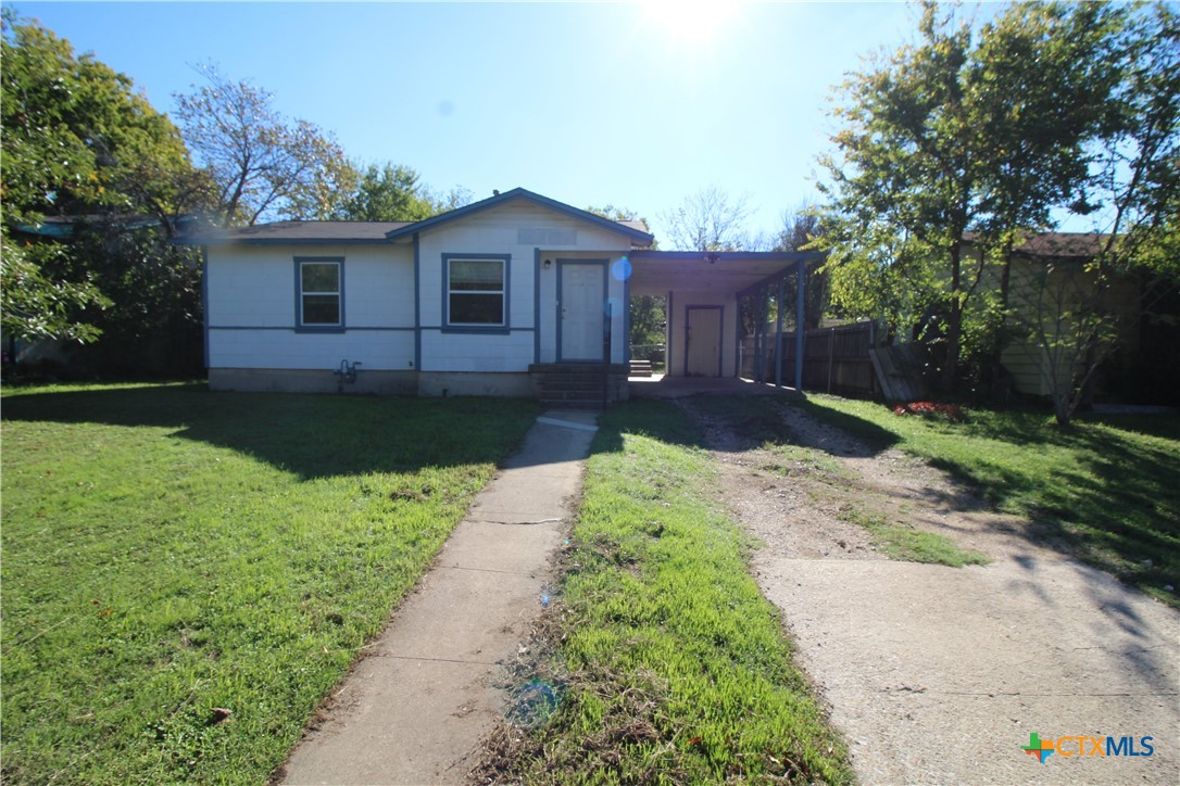 a front view of a house with a garden and yard