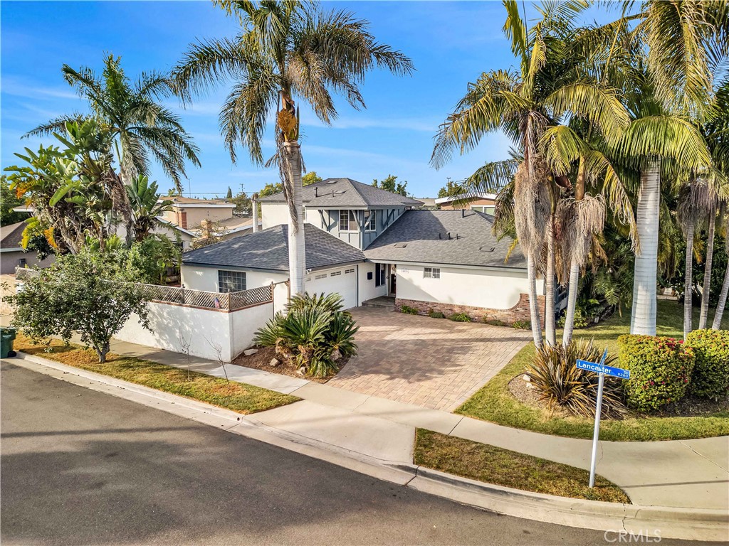 a view of a house with a yard and palm trees