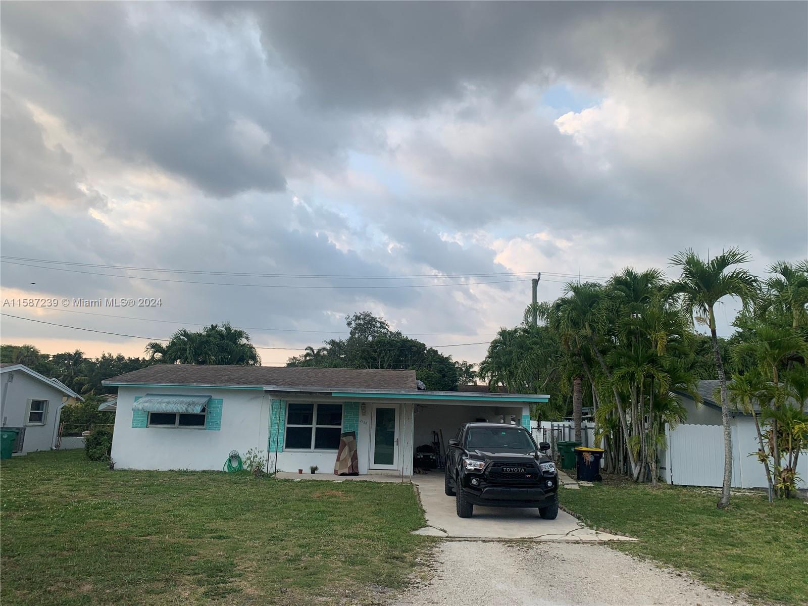 a car parked in front of house with a yard