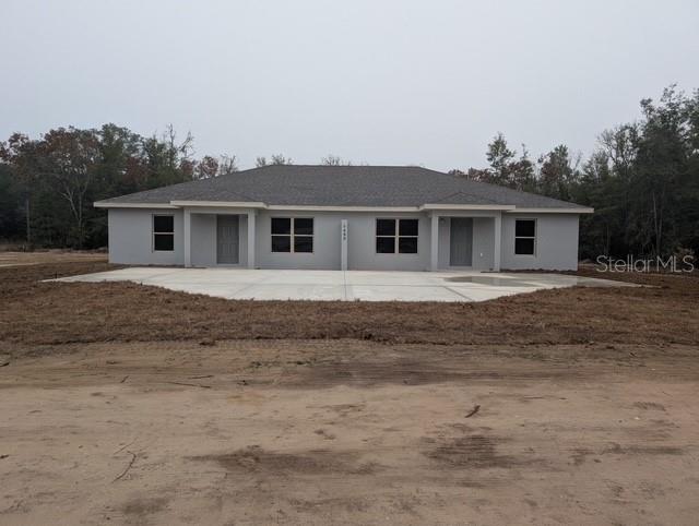 a front view of house with yard and trees around