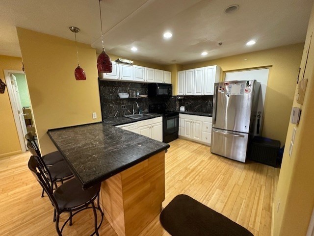 a kitchen with stainless steel appliances granite countertop a refrigerator a sink a stove a dining table and chairs