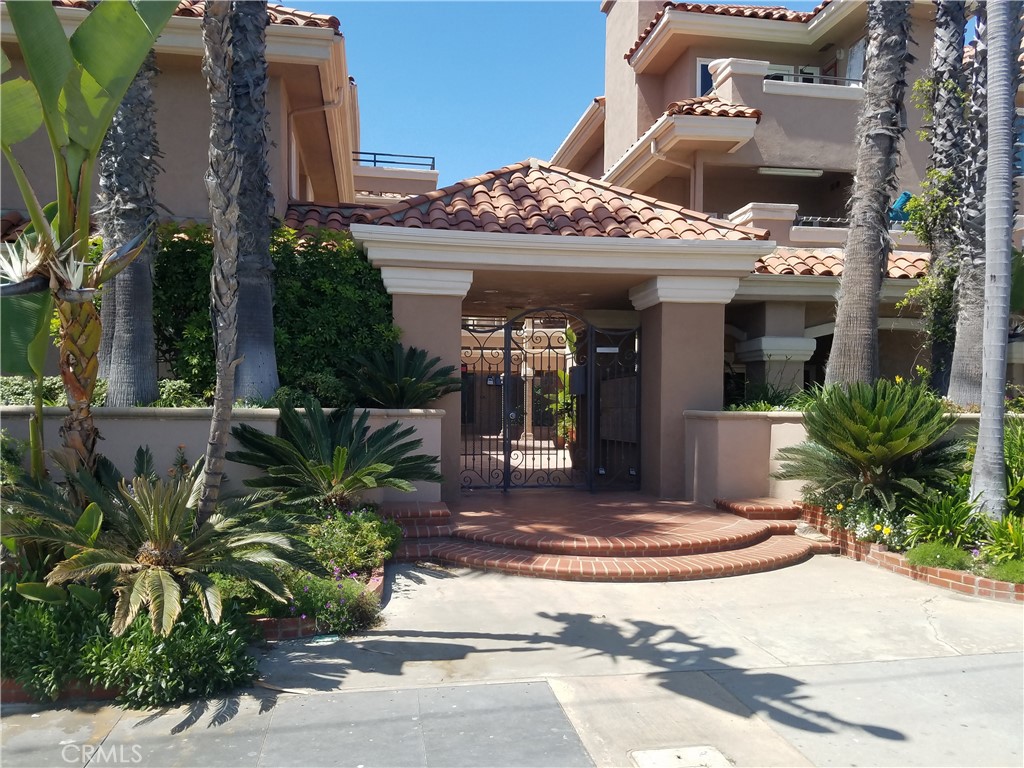 a view of a house with potted plants and a fountain