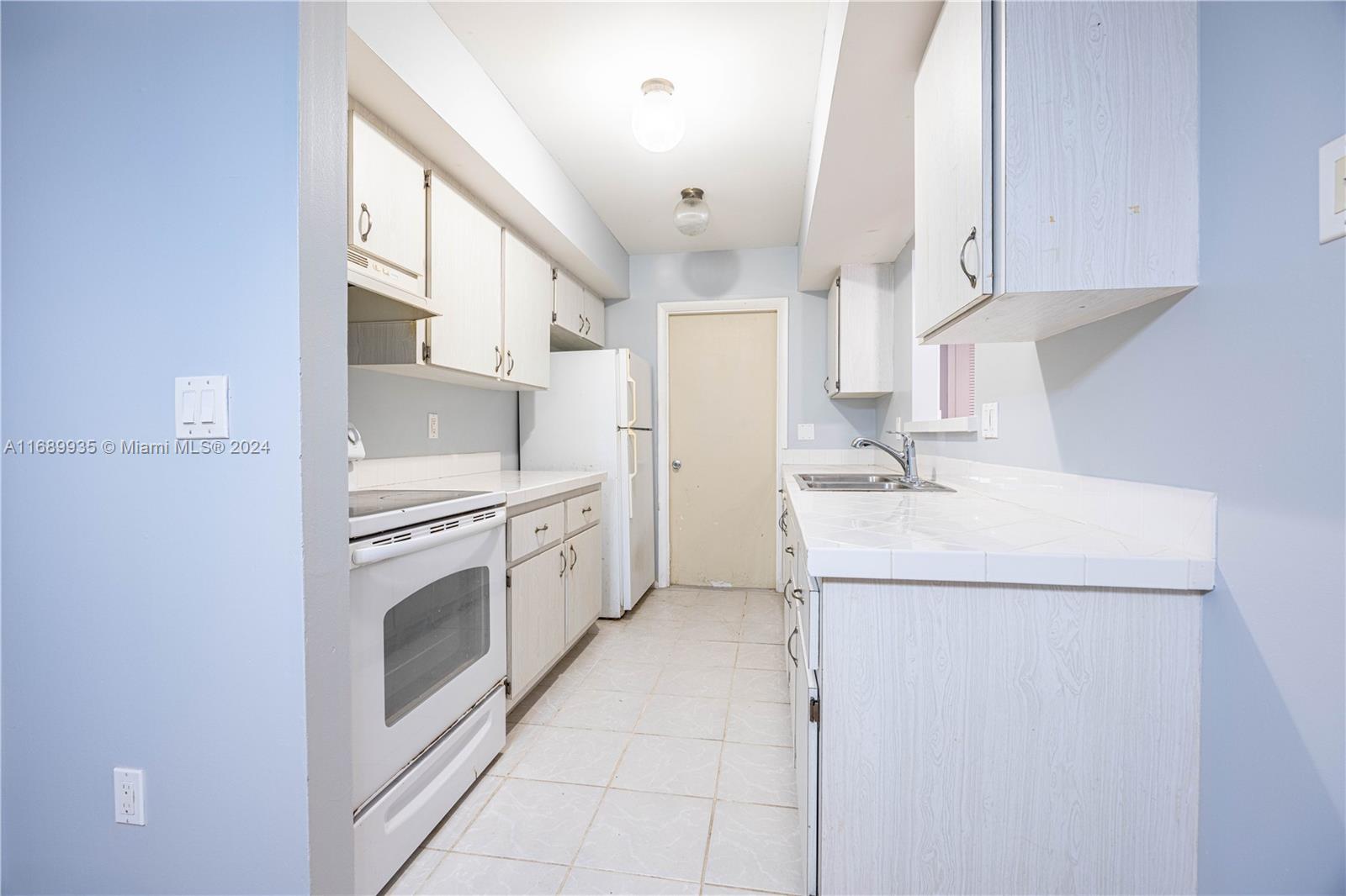 a kitchen with a sink cabinets and appliances