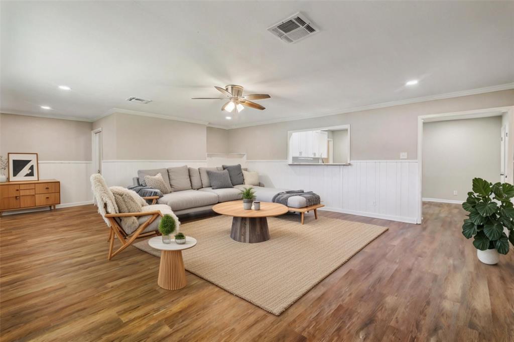 a living room with furniture and a wooden floor