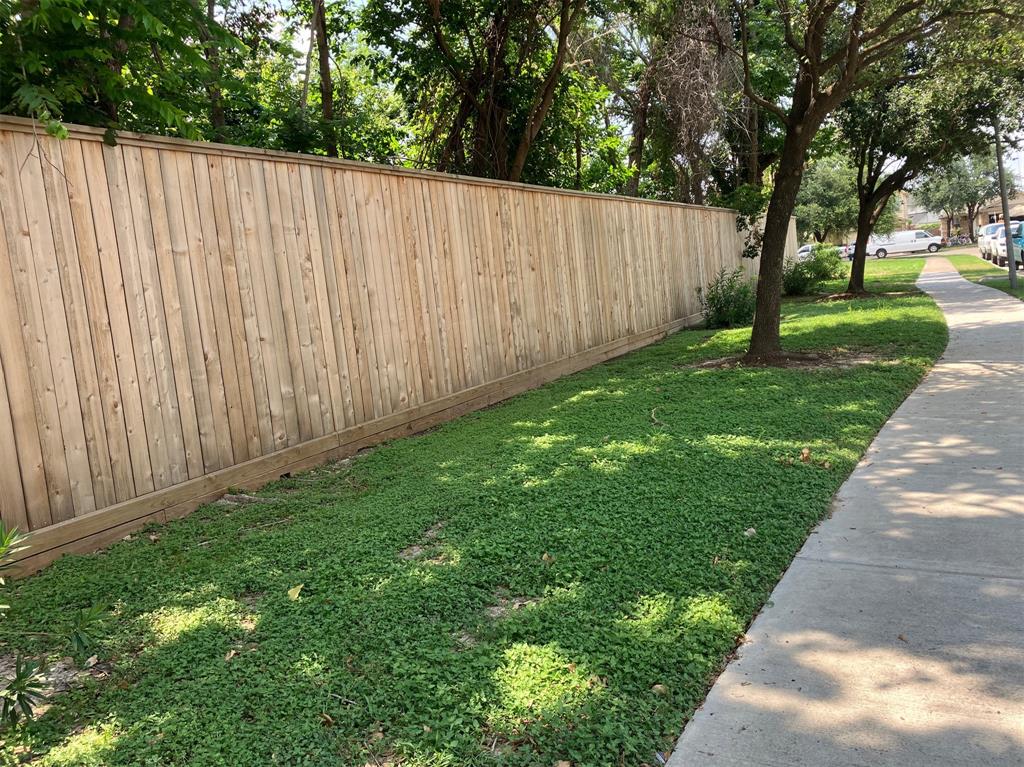 a view of a backyard with wooden fence