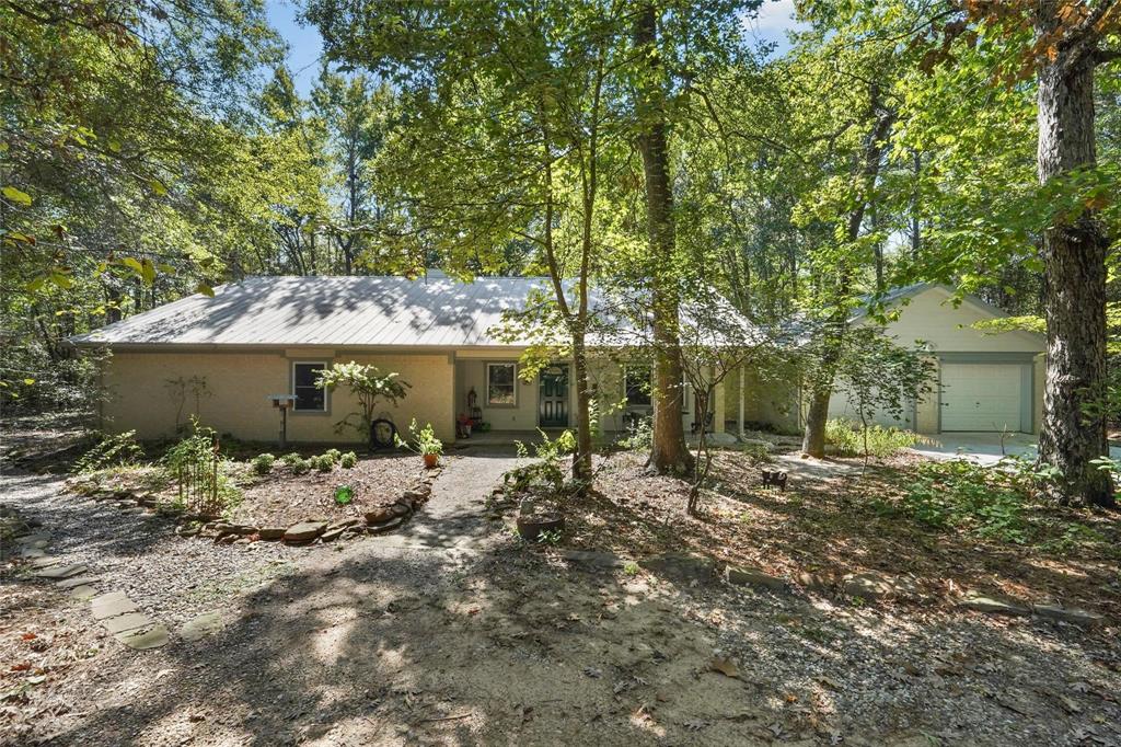 a view of a house with large trees and plants