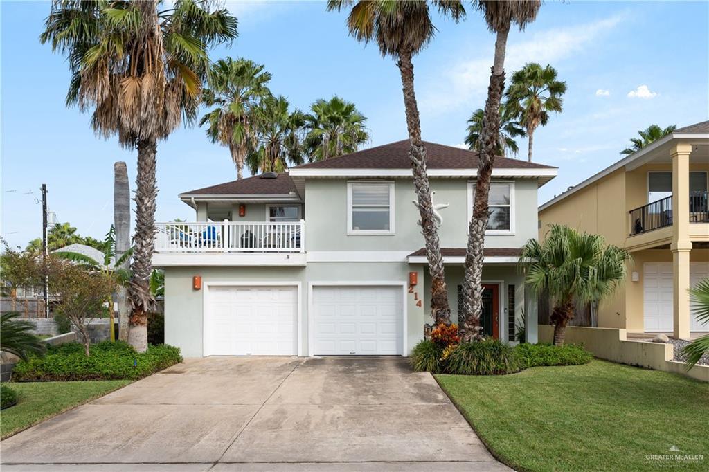 View of front facade featuring a garage, a balcony, and a front lawn