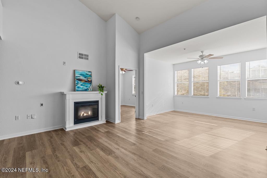 a view of an empty room with a fireplace and a window