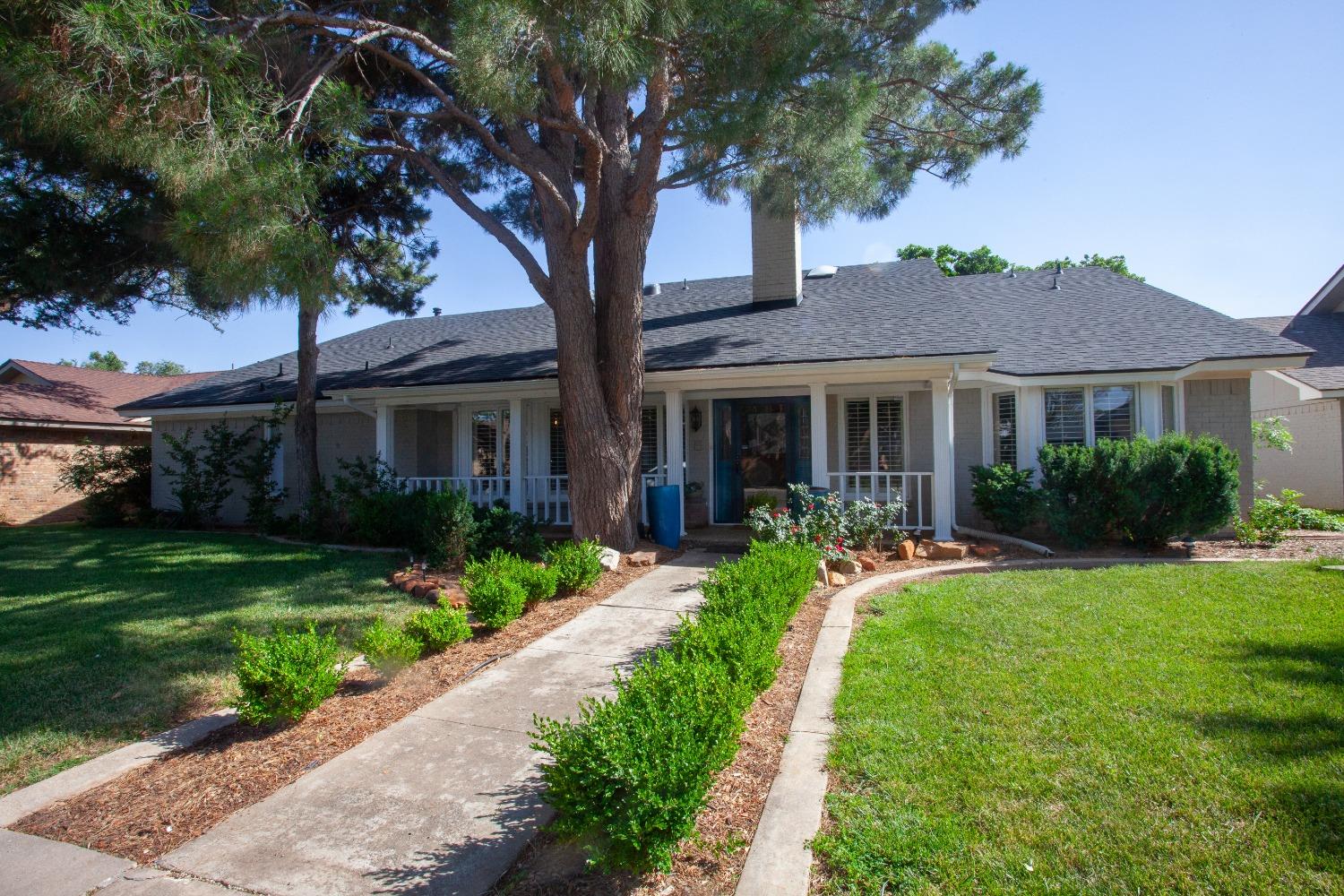 a front view of a house with yard and green space