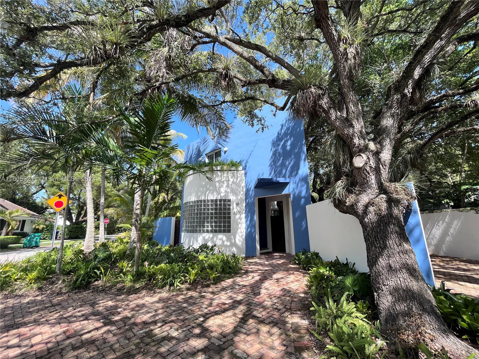 a front view of a house with a yard and tree s