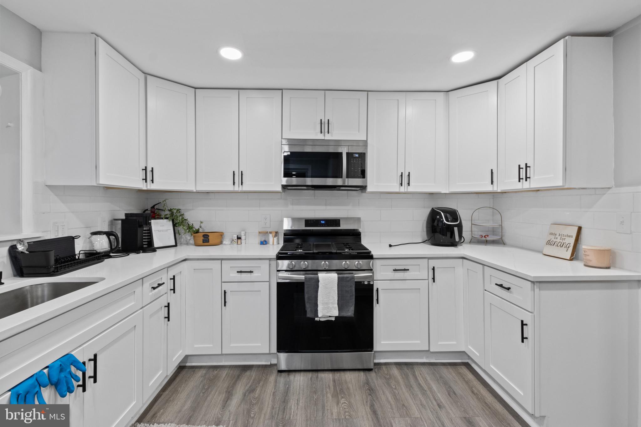 a kitchen with cabinets stainless steel appliances and wooden floor