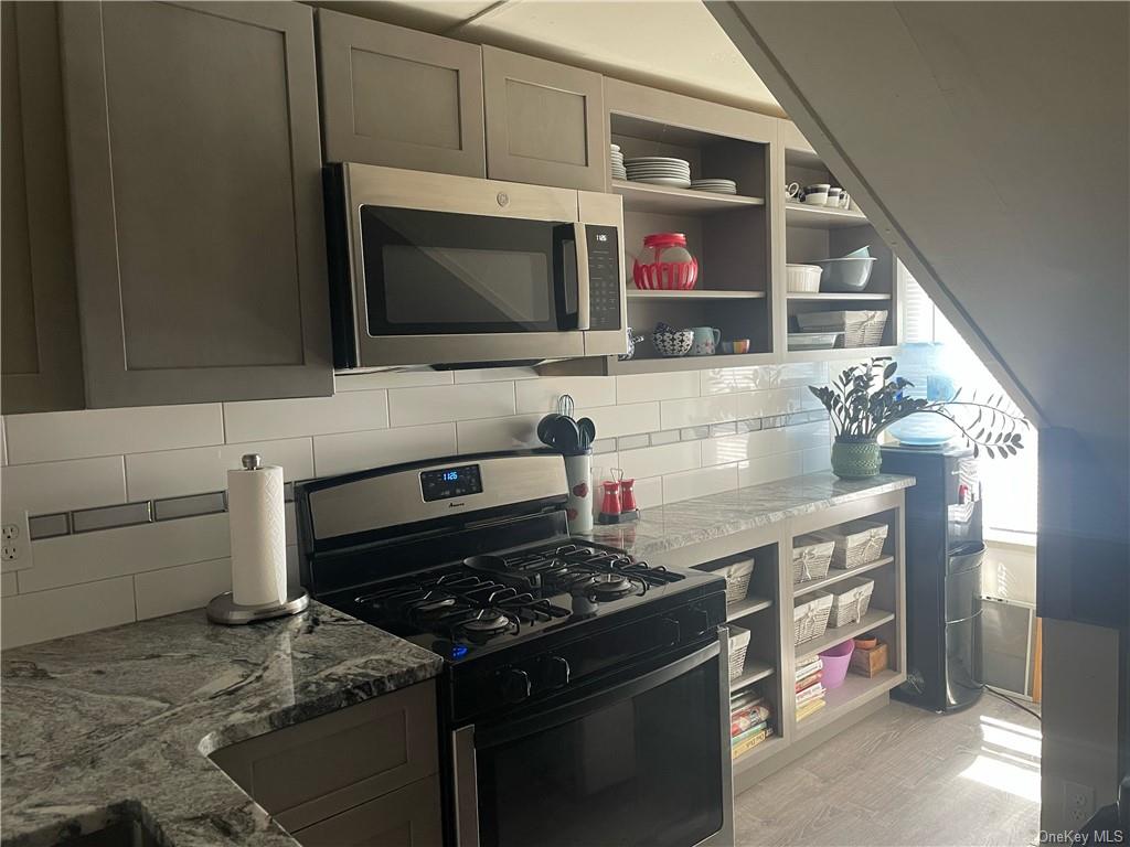 a kitchen with stainless steel appliances granite countertop a stove and a microwave