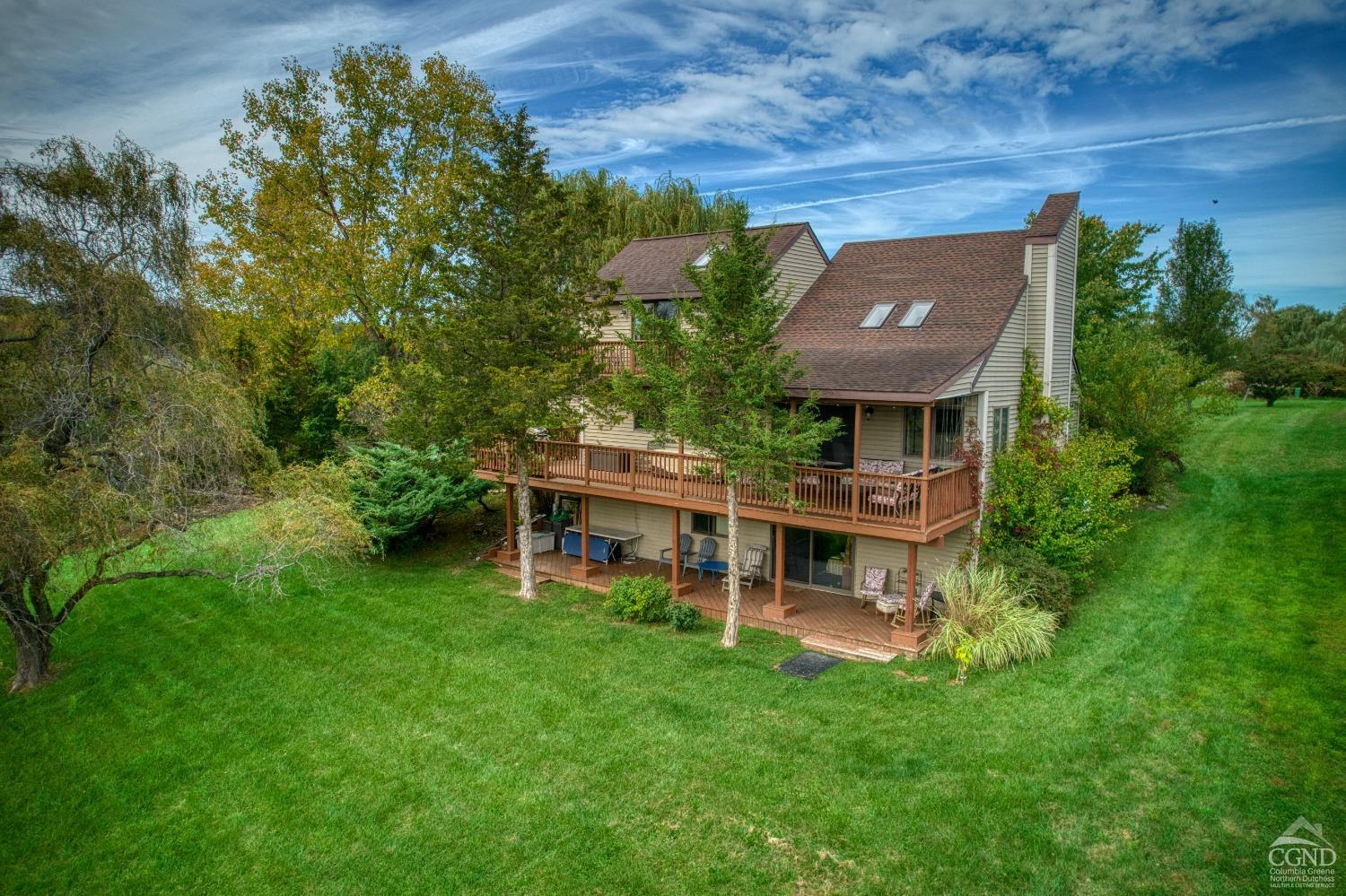 an aerial view of a house with a big yard potted plants and large tree