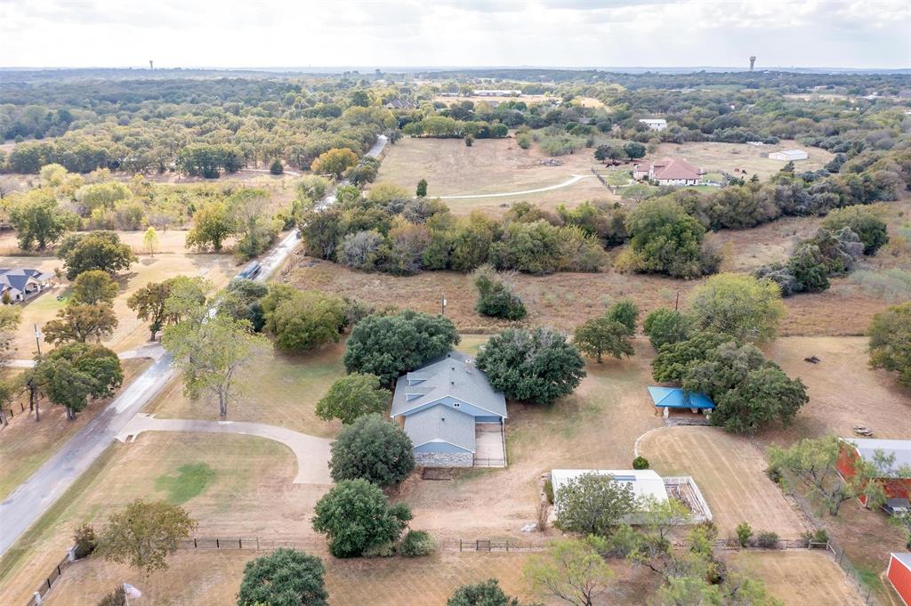 an aerial view of residential houses with outdoor space and trees