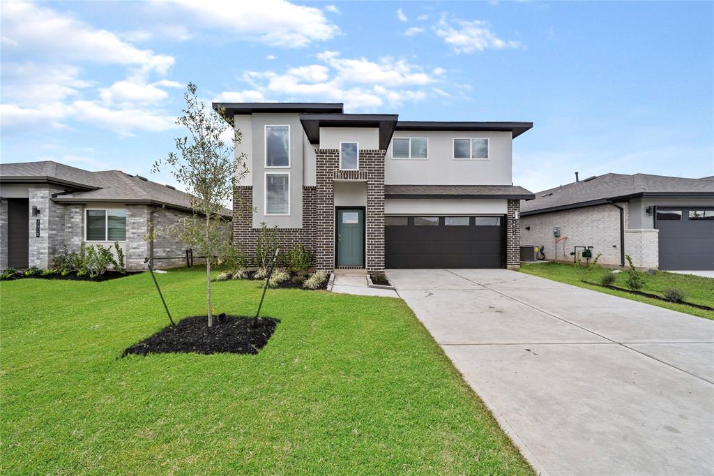 a front view of a house with a yard and garage