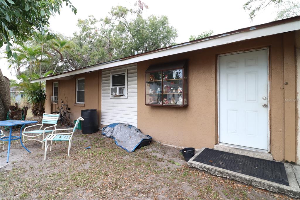 a backyard of a house with table and chairs