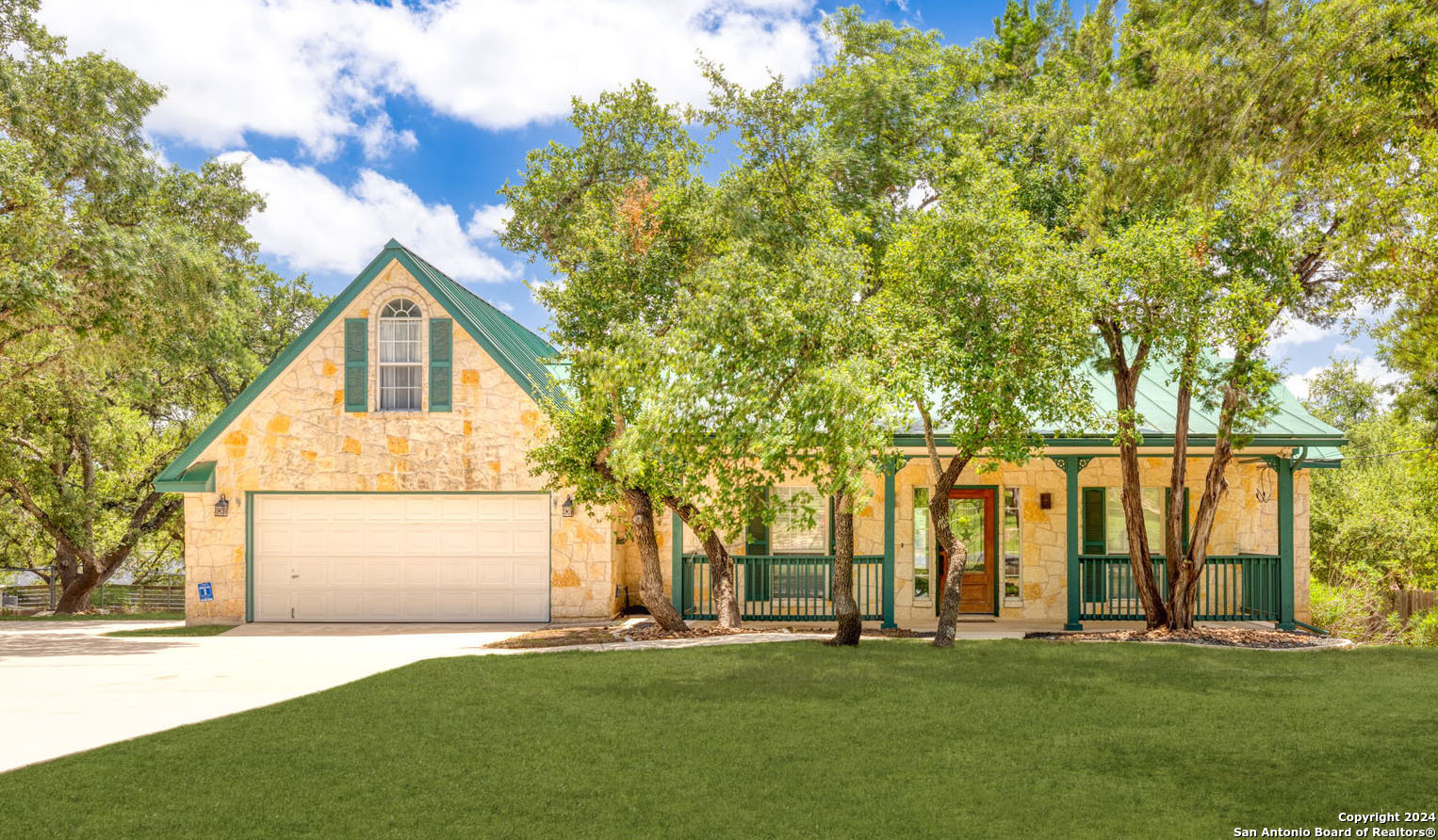 a front view of a house with a yard and trees