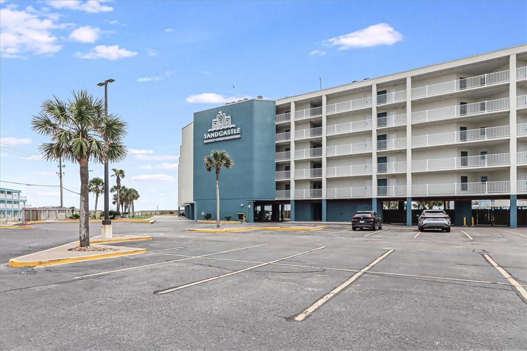 a view of a tall building with palm trees