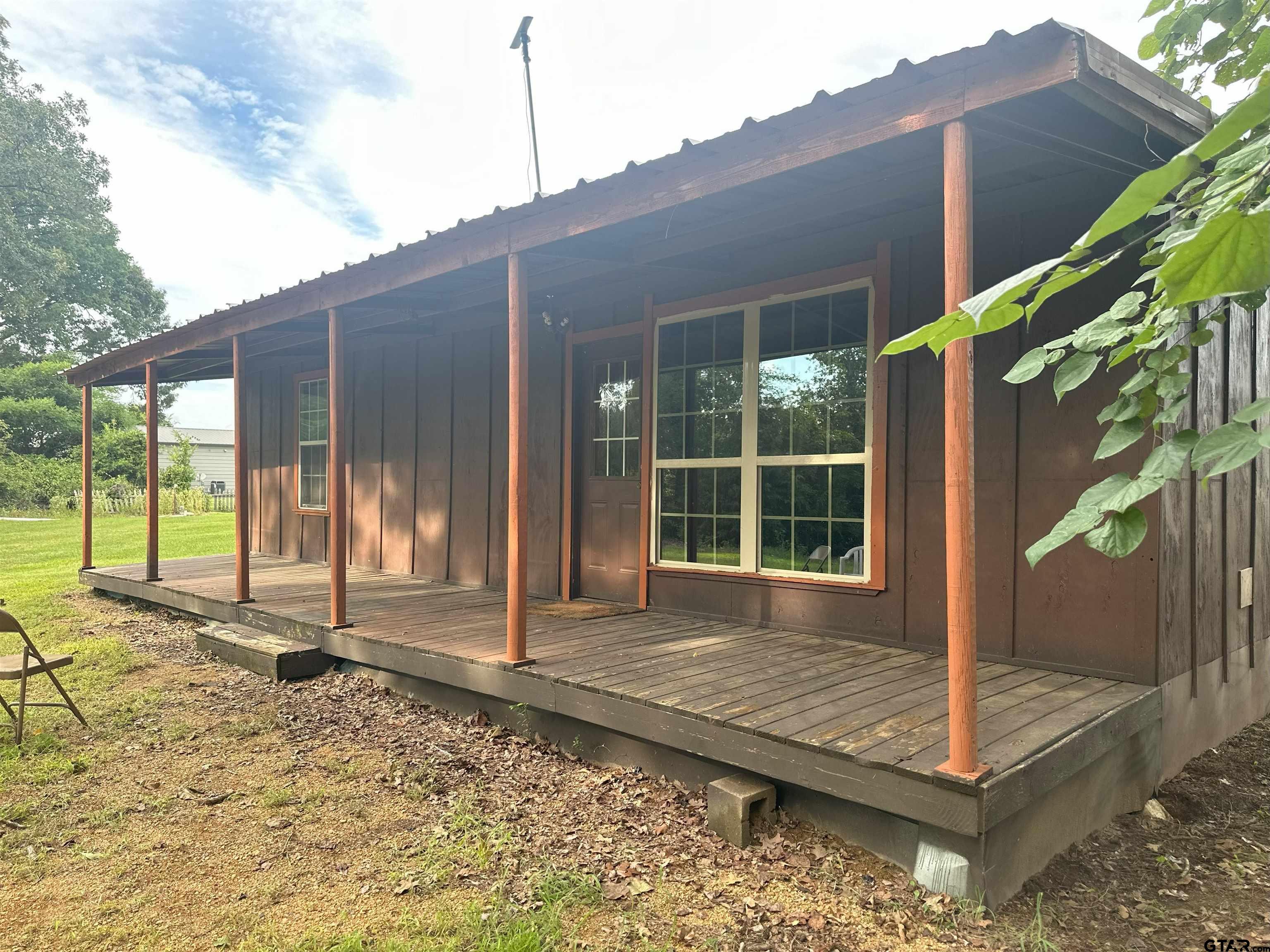 a view of house with backyard and glass windows