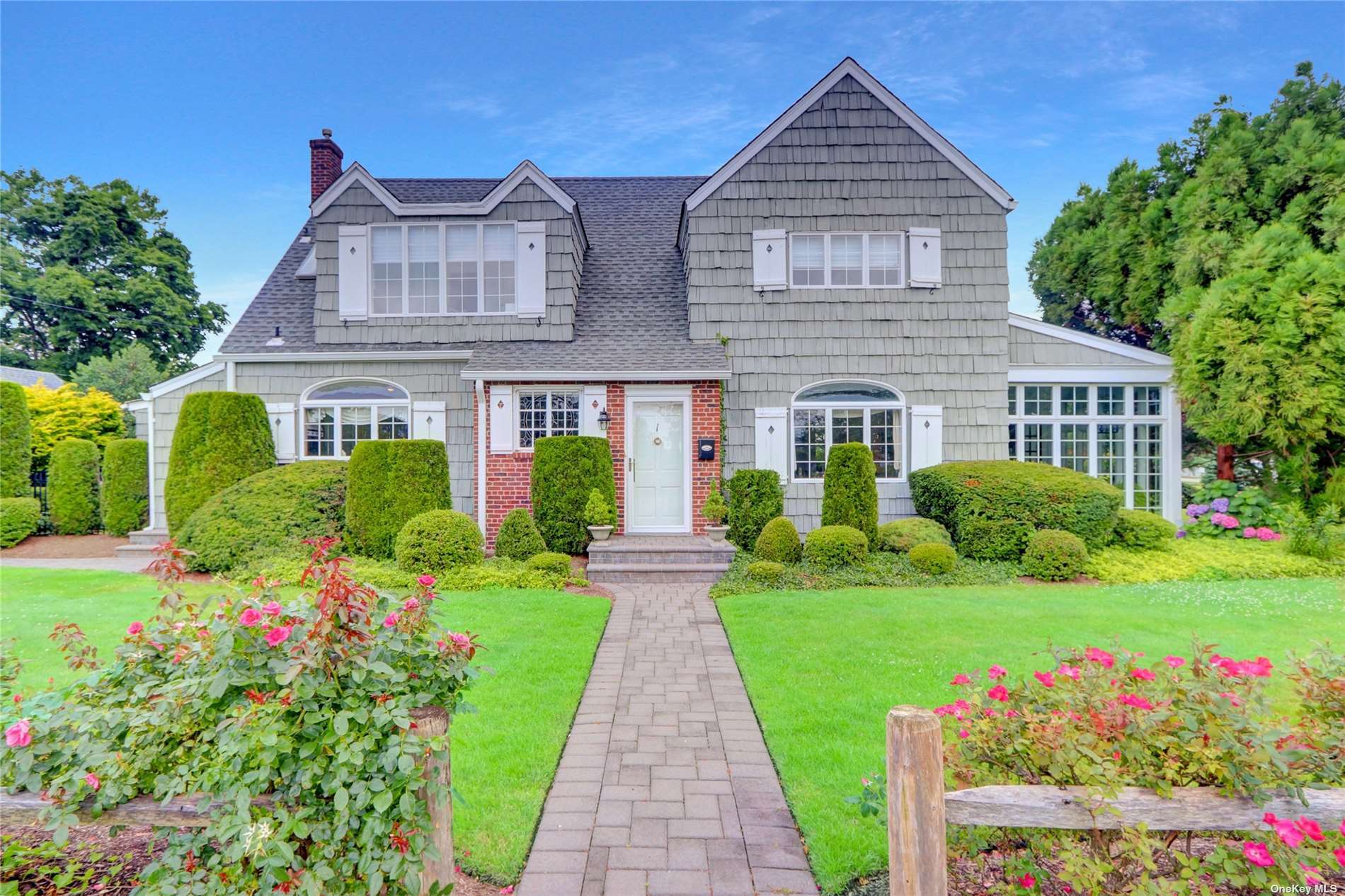 a front view of a house with a yard and potted plants