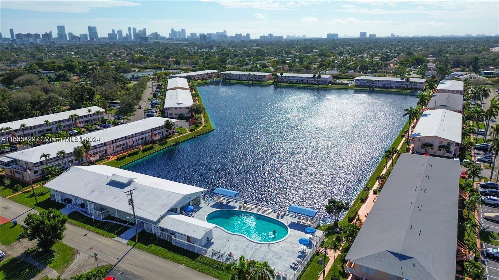 an aerial view of house with yard swimming pool and lake view