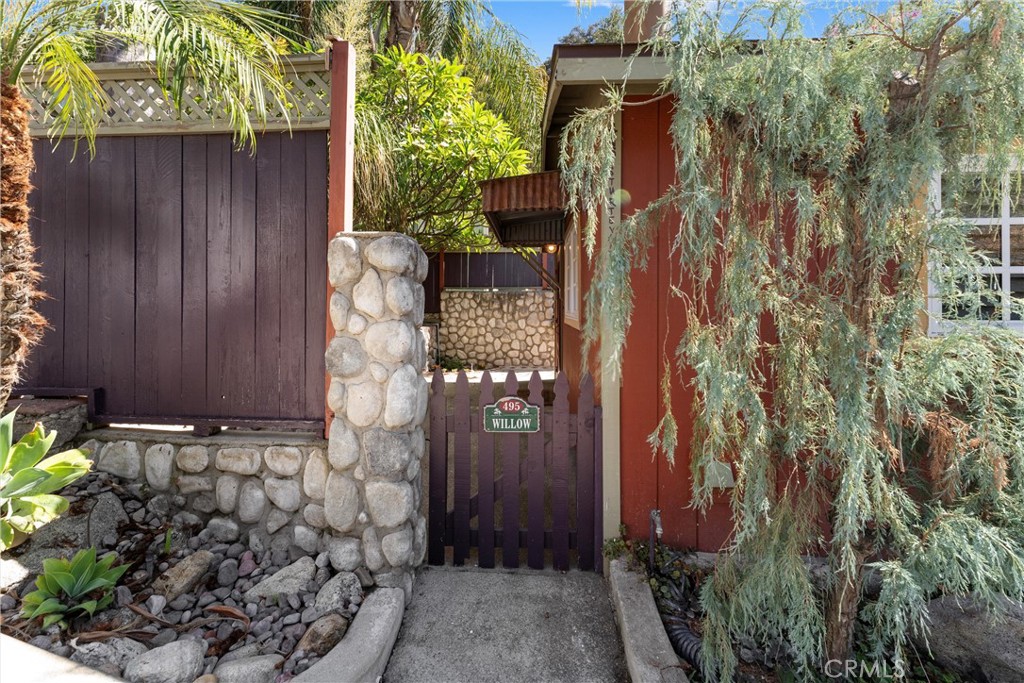 a view of a house with plants and wooden fence