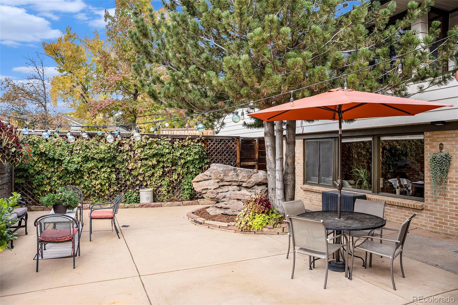 a patio with a table and chairs under an umbrella