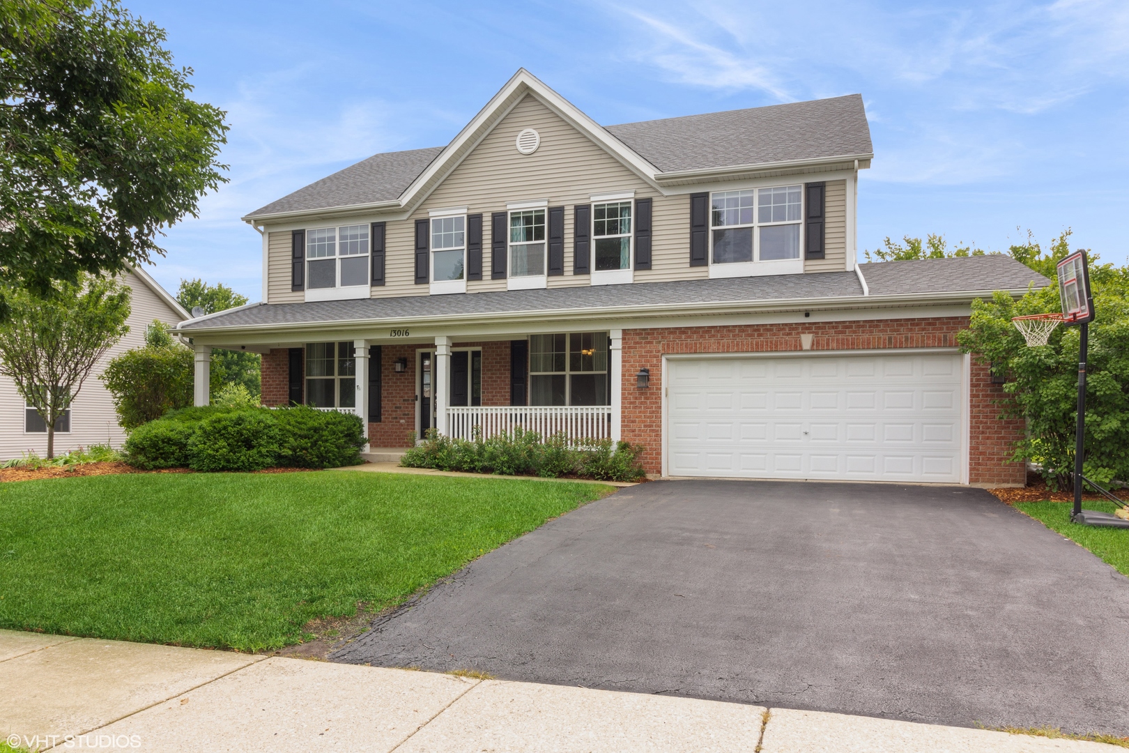 a front view of a house with a garden and garage